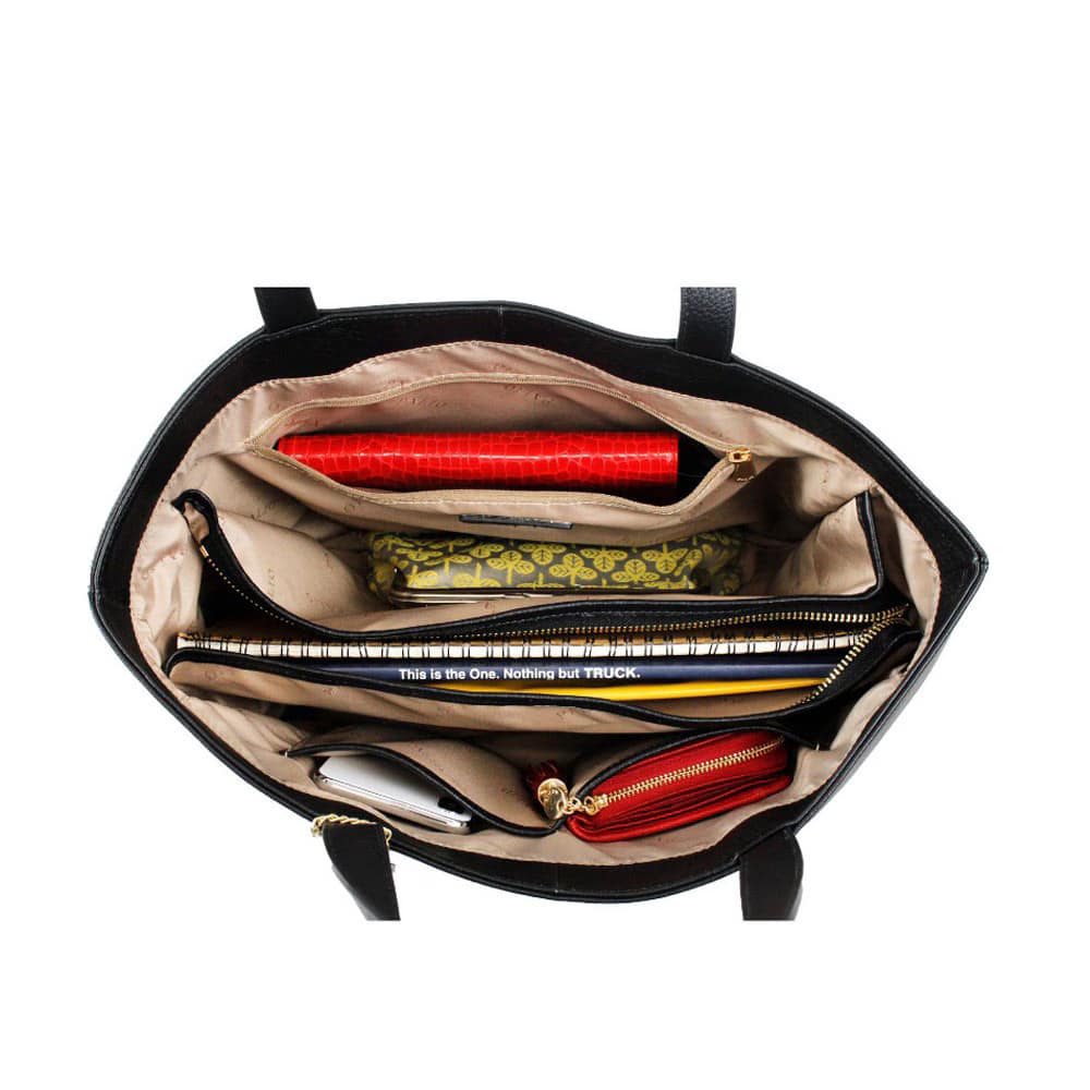20_000000000765 - SomethingBeautiful!! Open black handbag interior with tan lining, showing a red wallet, a patterned green wallet, a spiral notebook with a phrase, a phone, and a red zippered pouch.