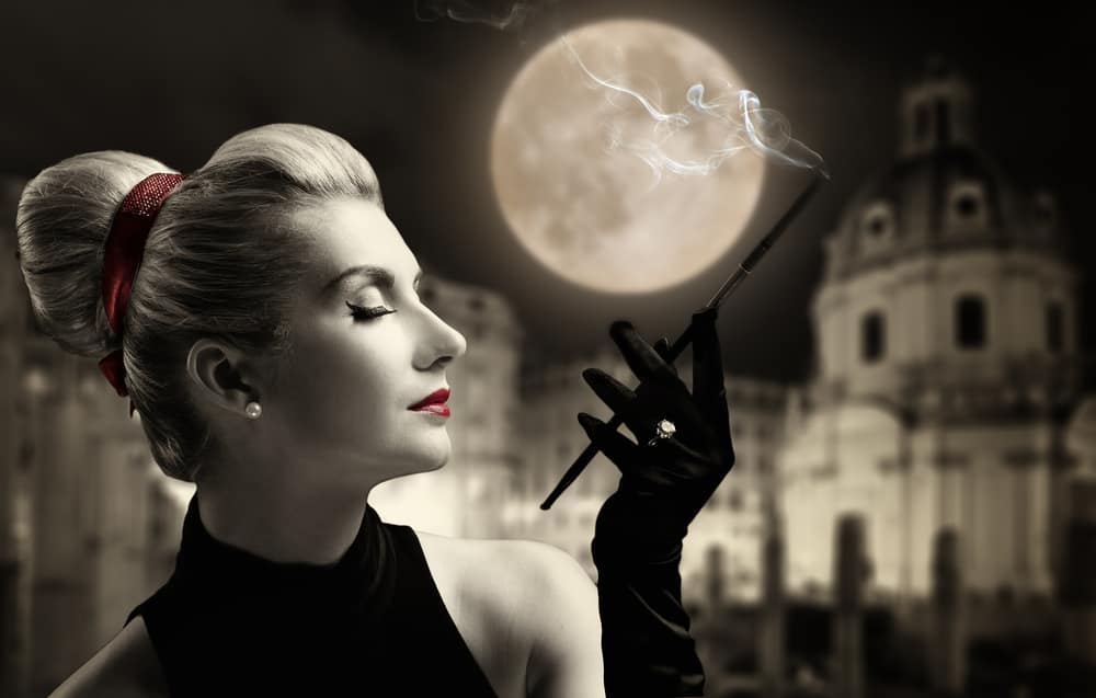 BeautifulYoungLadySmokingOldCityBehindHer - SomethingBeautiful!! Elegant woman in a vintage, black-and-white style smoking a cigarette against a full moonlit city backdrop.