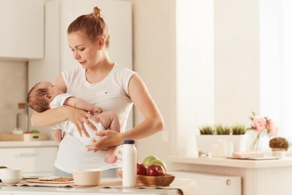 YoungMotherInWhiteT-shirtRockingHerBabyInKitchen - SomethingBeautiful!!