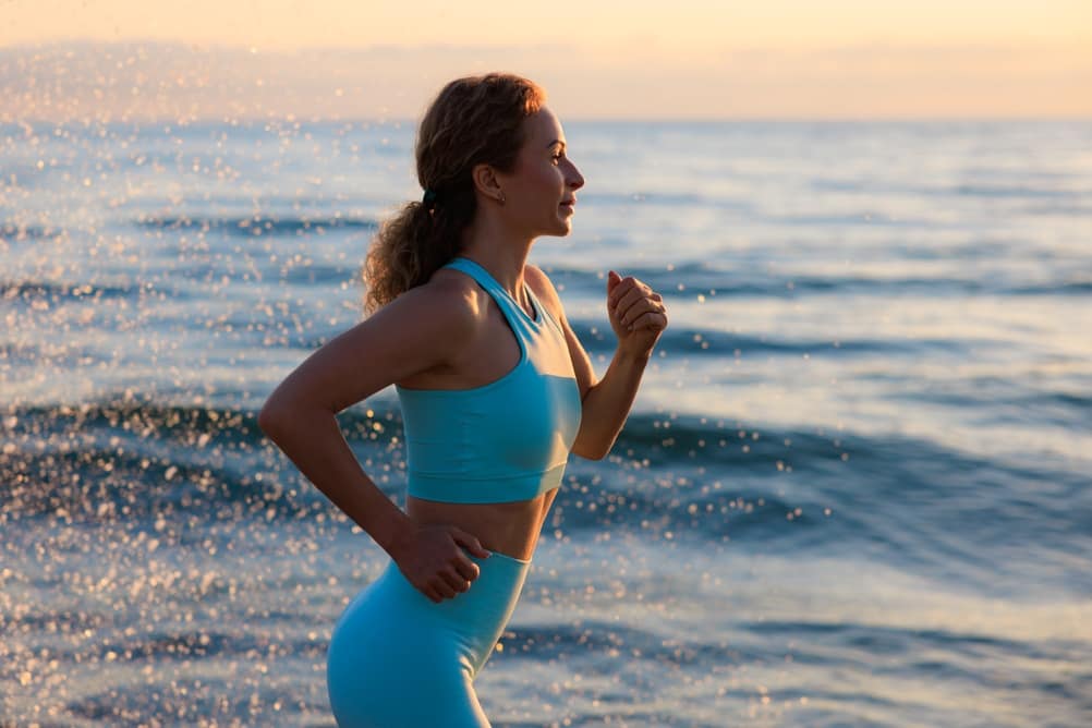 SportyYoungWomanIsRunningAgainstSeaBackgroundDuringHer - SomethingBeautiful!!