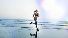 WomanJoggingOnABeachWearingAthleticGearOceanWaves - SomethingBeautiful!!