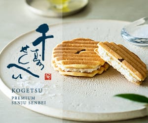 202306011006034700 - SomethingBeautiful!! Two cream-filled senbei crackers stacked on a white plate, with blue Japanese branding and the brand name 'KOGETSU Premium SENJU SENBEI' visible on the side.