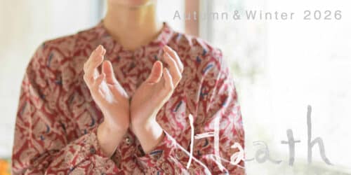 26awbanneryoko2-500x250 - SomethingBeautiful!! Close-up of a person in a red patterned outfit with hands raised; fashion lookbook cover for Kadath Autumn & Winter 2026.