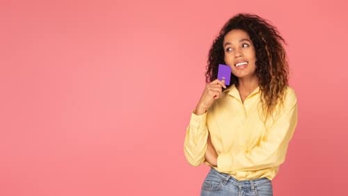 PensiveBlackWomanWithCreditCardConsideringPurchasesInYellow - SomethingBeautiful!!