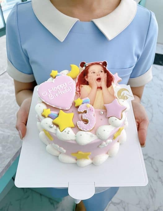 1781080036999b70c35b0520260221 - SomethingBeautiful!! Pastel birthday cake for a 3-year-old with a printed photo of a surprised girl, star and moon decorations, and pink frosting detail